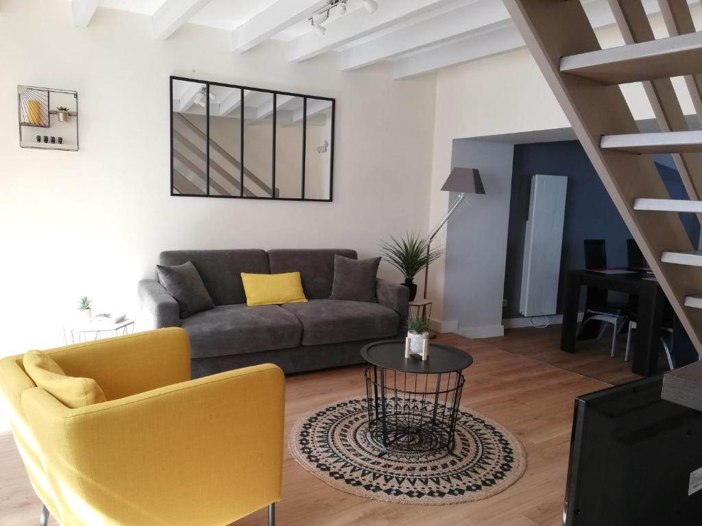 a living room with a couch and a table at Les Pénates in Saint-Laurent-sur-Sèvre