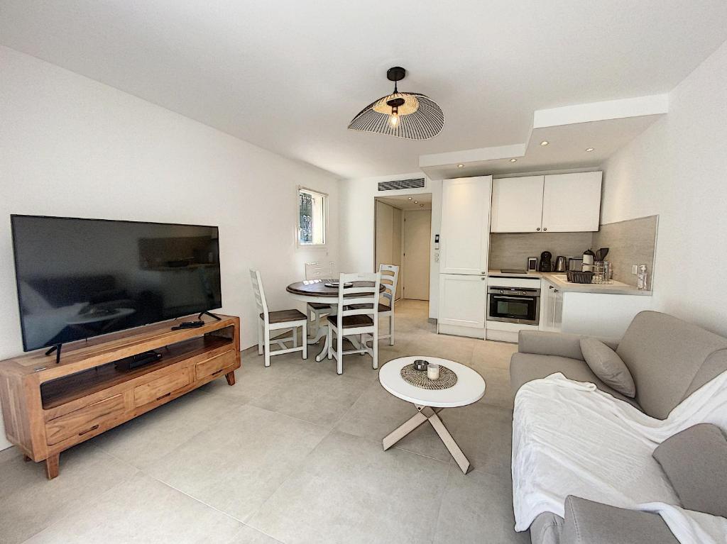 un salon avec une grande télévision à écran plat dans l'établissement Superbe appartement au cœur du Cap d'Antibes, à Antibes