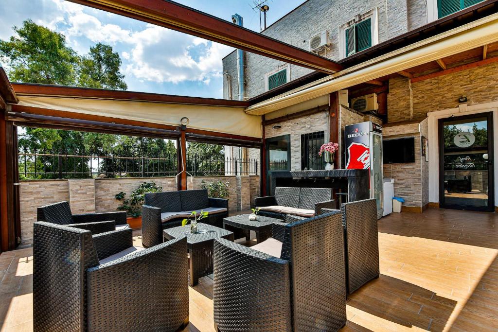 eine Terrasse mit Korbstühlen und Tischen auf einer Terrasse in der Unterkunft E-Room 42 in Rom