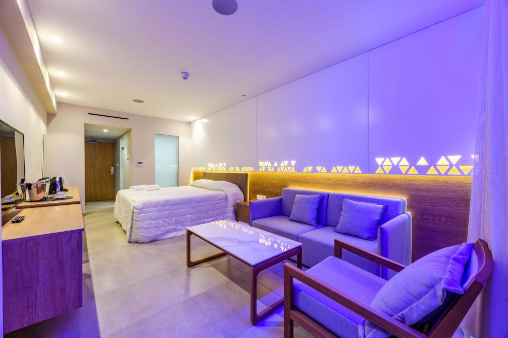 a hotel room with purple furniture and a bed at Seasons Hotel (Adults Only) in Ayia Napa