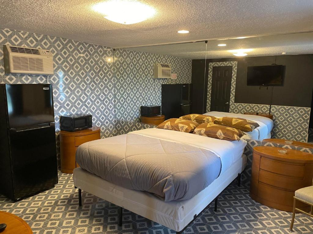 a bedroom with two beds and a flat screen tv at Carole Motel in Savannah
