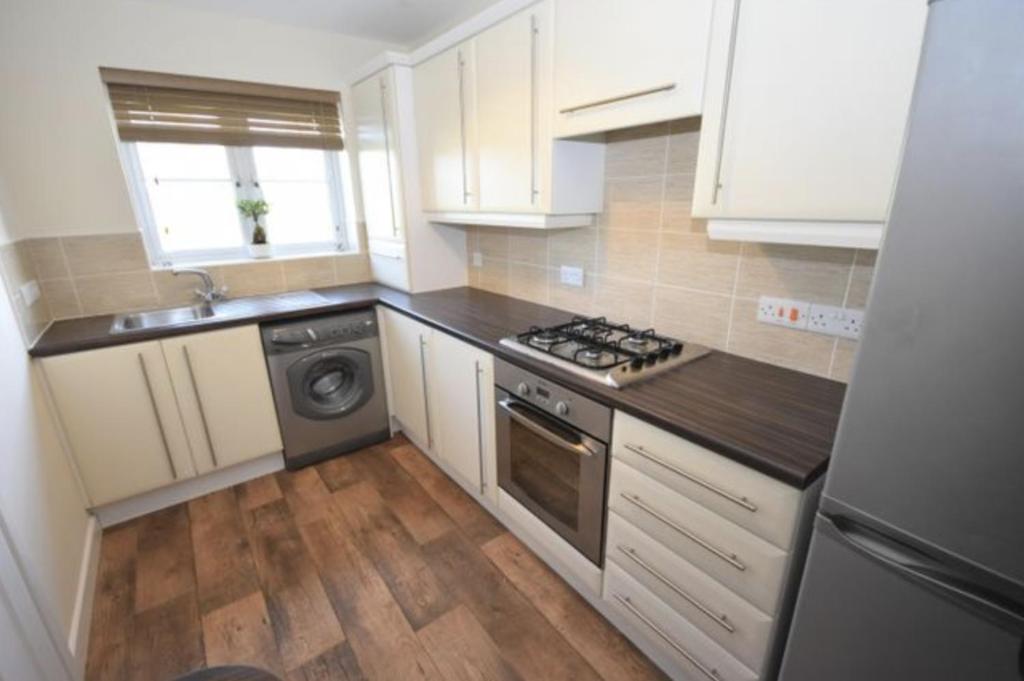 a kitchen with white cabinets and a stove top oven at Brockwell - 2 Bed Modern Home, Near City Centre in Bowburn