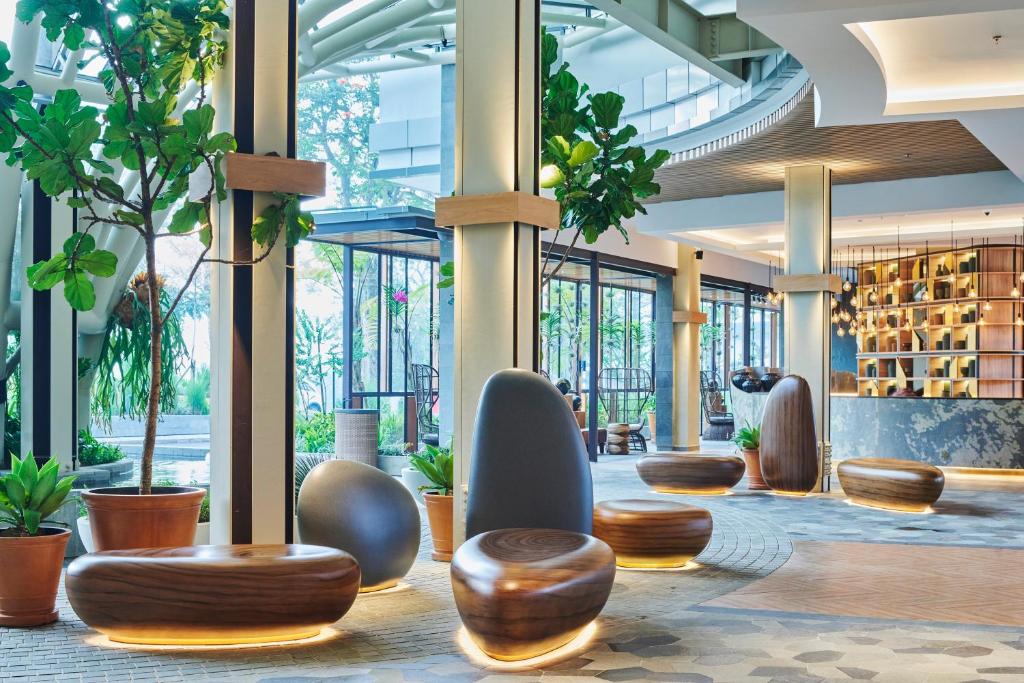 a lobby of a building with trees and plants at The Botanica Sanctuary in Puncak