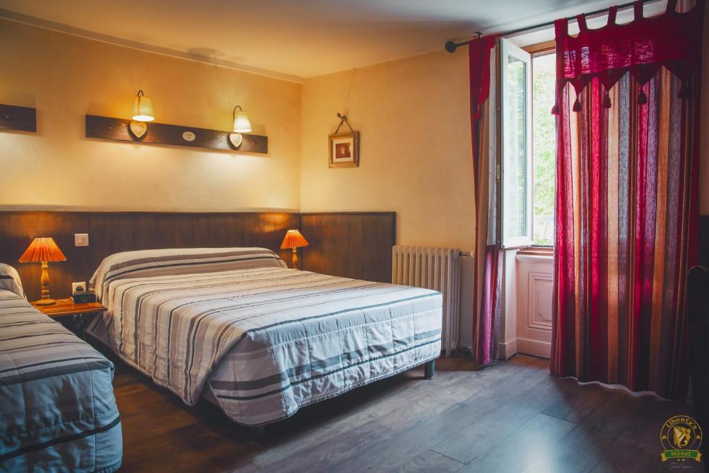 um quarto com uma cama grande e uma janela em The Liberty's em Villefranche-sur-Saône