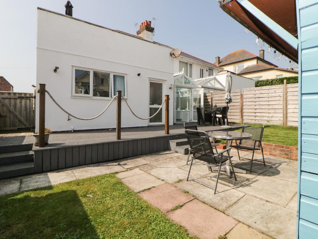 a patio with a table and chairs in a yard at Pier View in Paignton