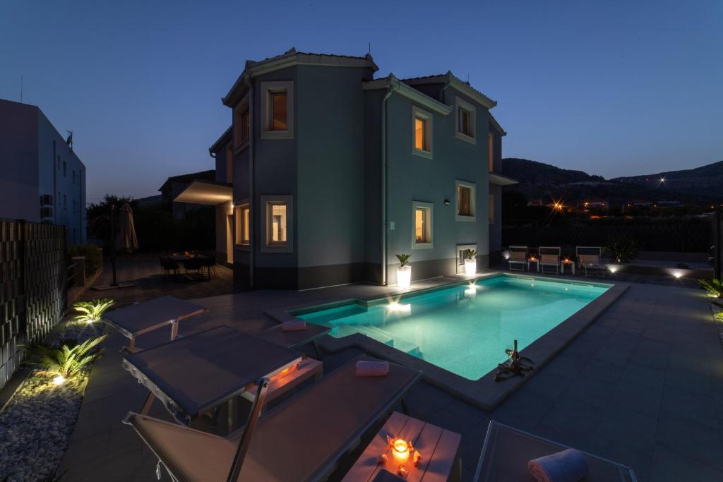 eine Villa mit einem Pool in der Nacht in der Unterkunft Villa Ban in Trogir