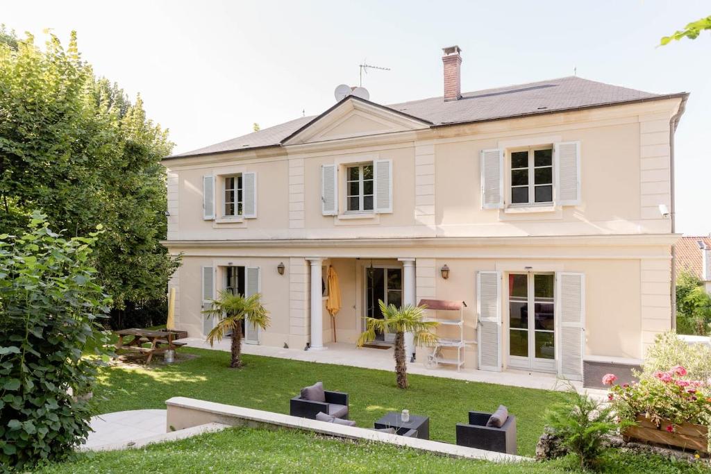 duży biały dom z ogródkiem w obiekcie la source de bougival w mieście Bougival