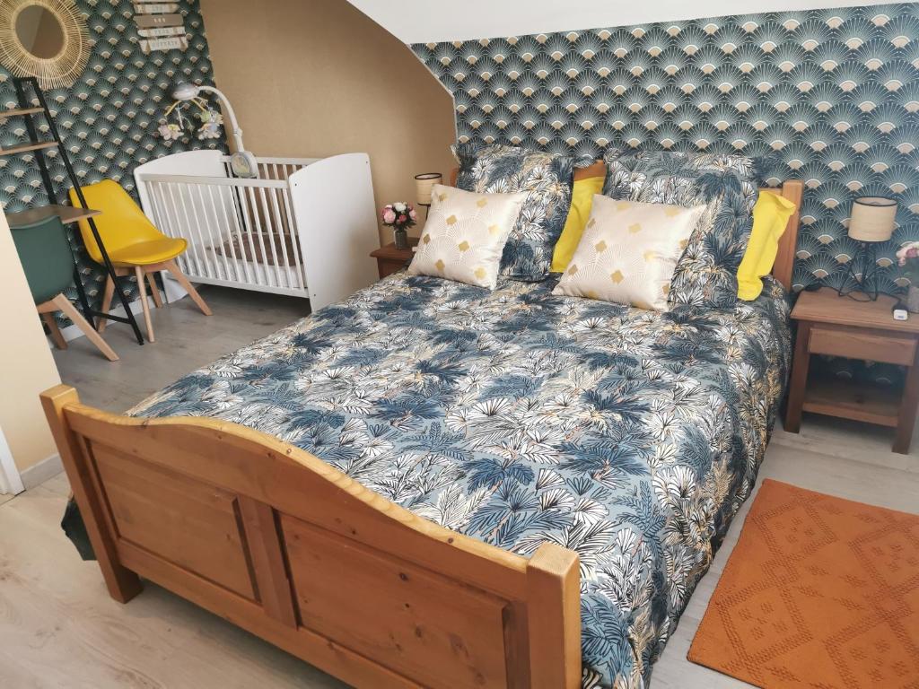 Schlafzimmer mit einem Bett mit blauer Decke in der Unterkunft Bienvenue chez moi à Concevreux in Concevreux