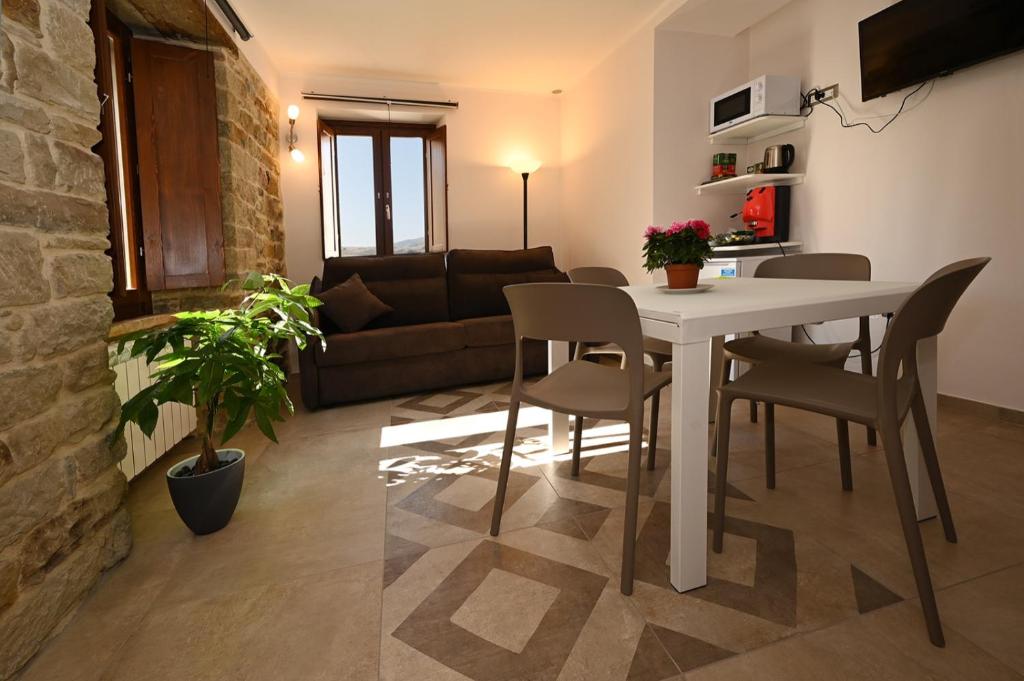a kitchen and living room with a table and chairs at Petra Holiday Home in Pietrapertosa