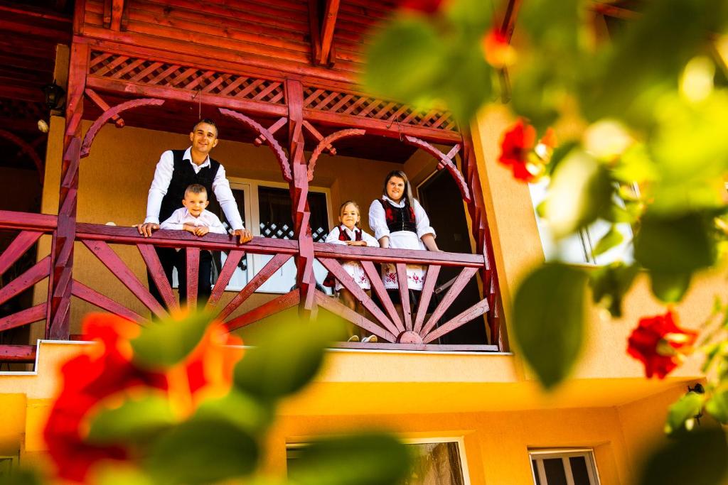 een bruid en bruidegom en hun kinderen op een balkon bij Pensiunea Fábián Vendégház in Corund
