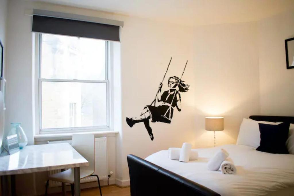 a bedroom with a man on a swing on the wall at GuestReady - Calm and Central sleeps up to 6 in Edinburgh