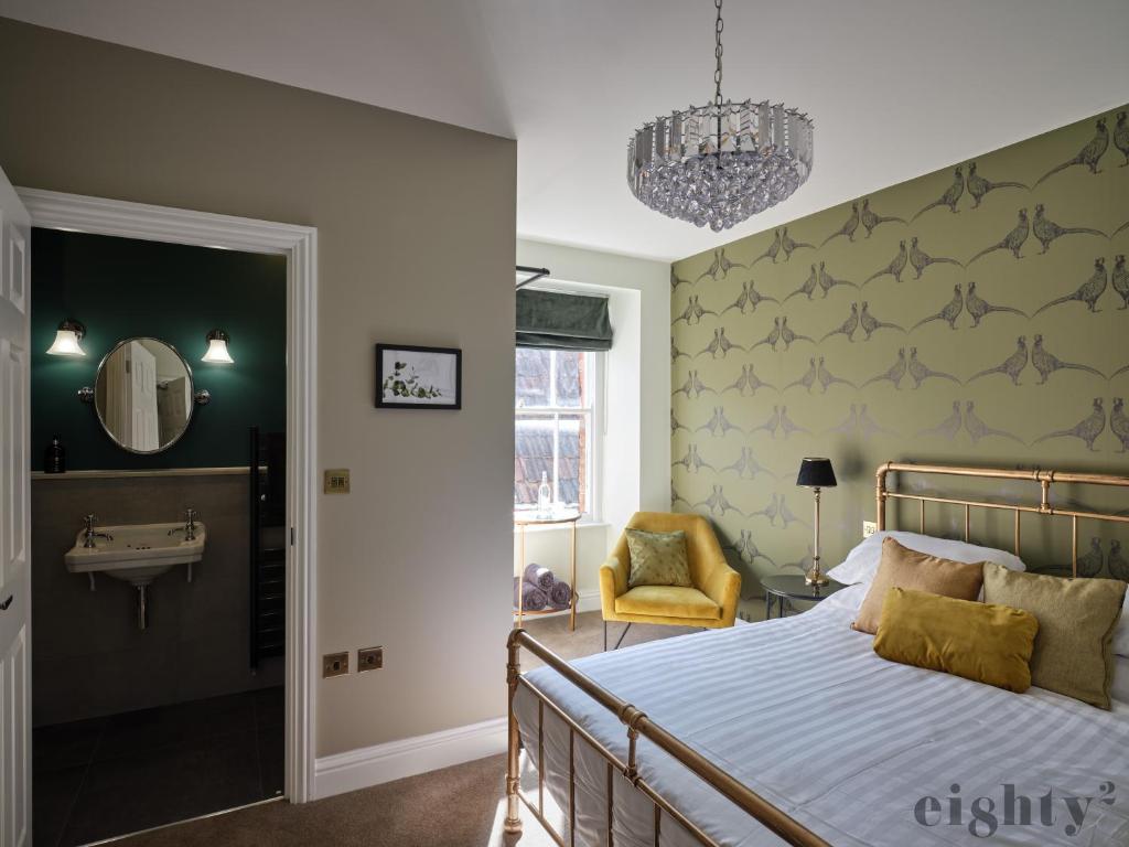um quarto com uma cama, um lavatório e um espelho em The Prince of Waterloo - Boutique Guest Rooms em Winford