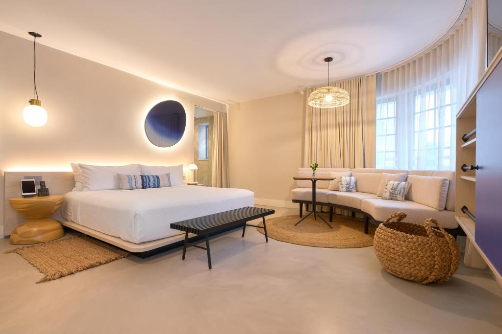 a bedroom with a white bed and a couch at Hotel Greystone - Adults Only in Miami Beach
