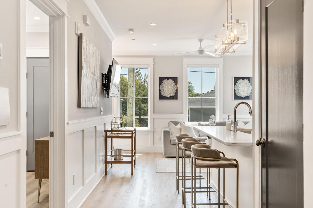 チャールストンにあるThe Jasmine Suite at 124 Springのバースツール付きのキッチン、白い壁のキッチン