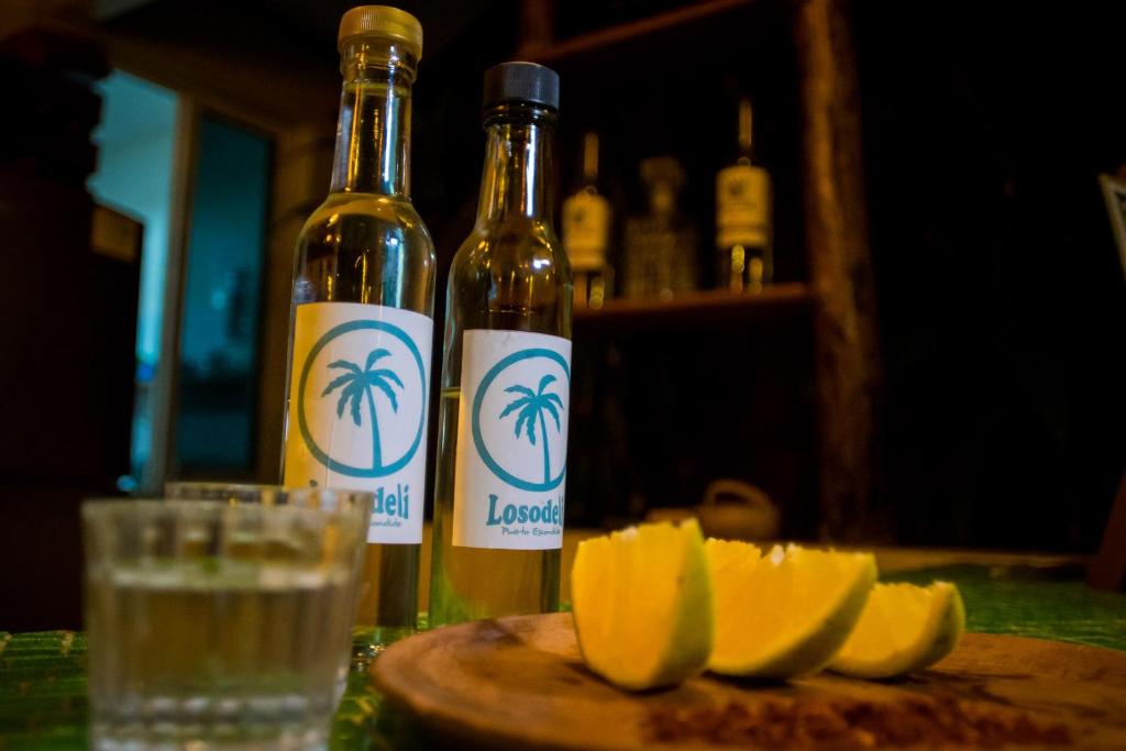 two bottles of wine and a plate of sliced lemons at Casa Losodeli & Coworking- Adults Only in Puerto Escondido