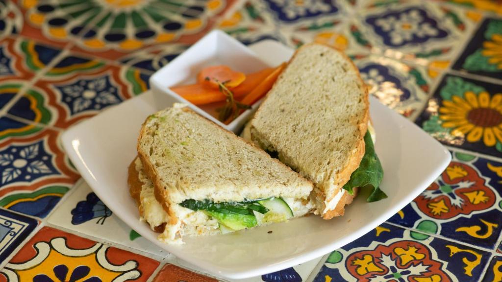 a sandwich on a plate with carrots on a table at Casa Losodeli & Coworking- Adults Only in Puerto Escondido