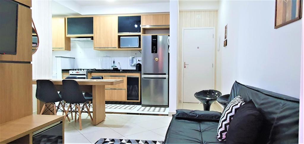een keuken en een woonkamer met een bank en een tafel bij Apartamento 2 Novíssimo e Bem Localizado - Itaguá - UBATUBA-SP in Ubatuba