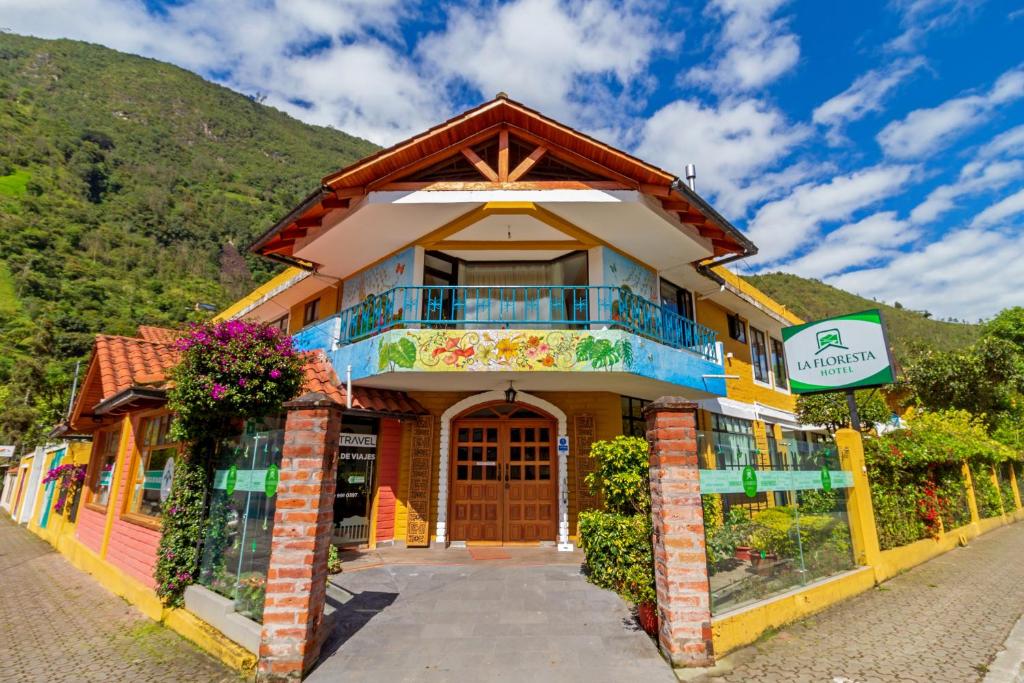 a house with a blue roof and a blue door at La Floresta Hotel in Baños