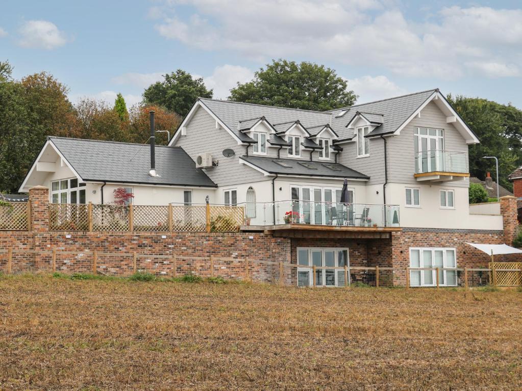 uma grande casa branca com uma parede de tijolos em Slitting Mill Annex em Rugeley