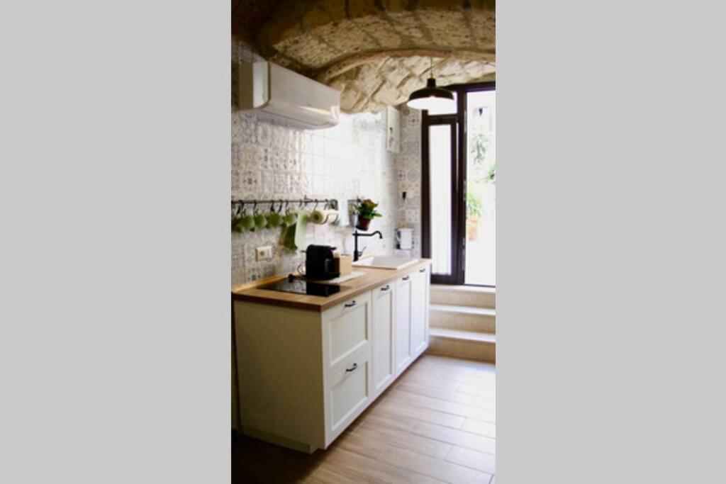 a kitchen with white cabinets and a sink at Gesuiti 25 in Bari