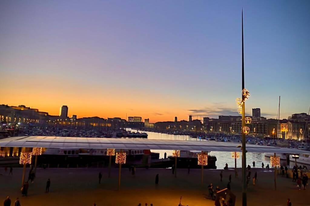 a view of a city at sunset with a body of water at LE M Luxueux appartement sur le Vieux port de Marseille in Marseille