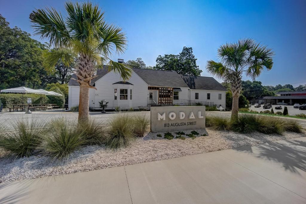 una señal frente a una casa con una palmera en Modal, en Greenville