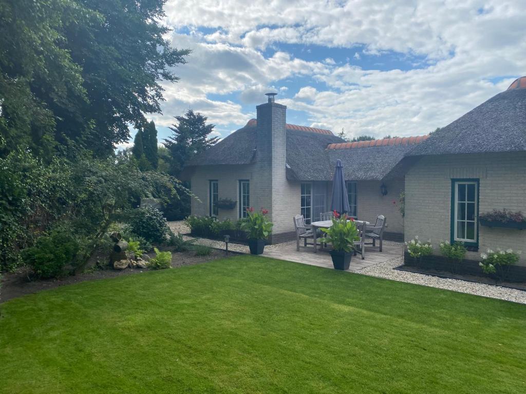 un patio trasero de una casa con césped verde en Aaltje’s Hoeve, en Ermelo