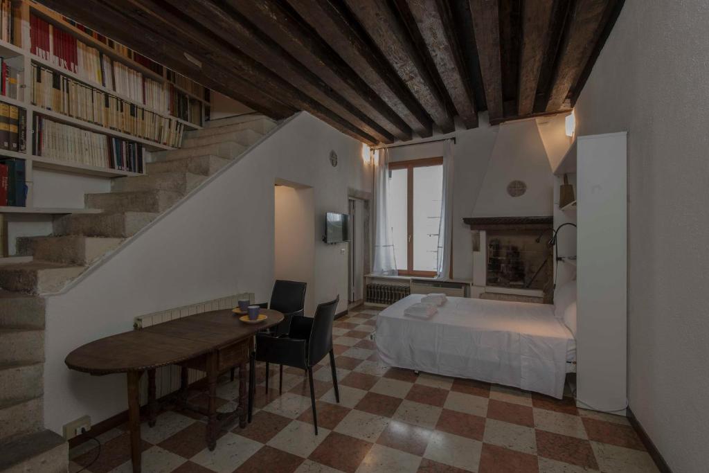 1 dormitorio con cama, mesa y escalera en Ca’Barbarigo, en Venecia