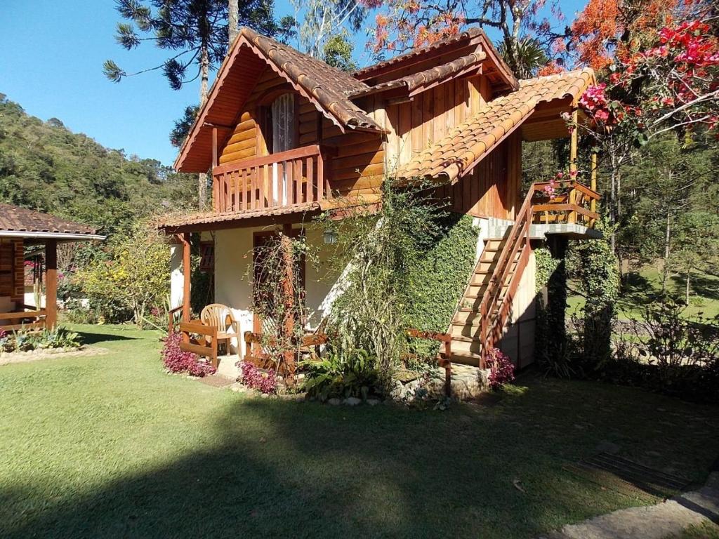 eine Blockhütte mit einer Treppe im Hof in der Unterkunft Pousada Céu Aberto - Visconde de Mauá - Maringá MG in Itatiaia