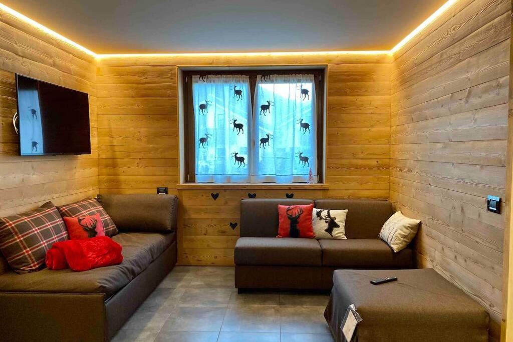 ein Wohnzimmer mit 2 Sofas und einem Fenster in der Unterkunft La petite maison d'Erika in Aosta