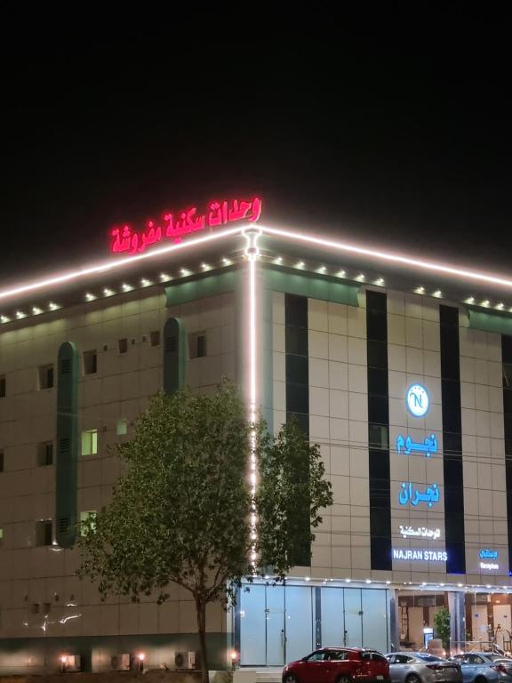 budynek z neonem na górze w obiekcie نجوم الكون للشقق المخدومة w mieście Nadżran