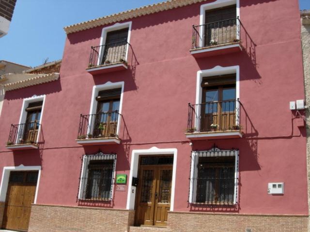 een roze gebouw met balkons aan de zijkant bij Casa Rural Carcelen in Carcelén