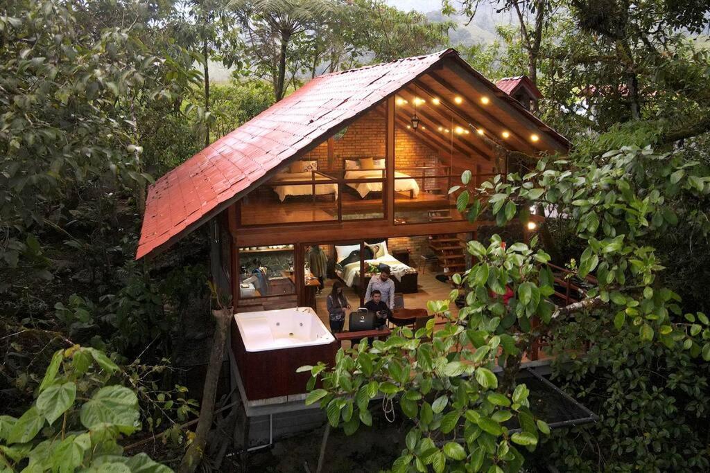 una pequeña casa en el árbol con techo rojo en Luxury cabin surrounded by nature en Baeza