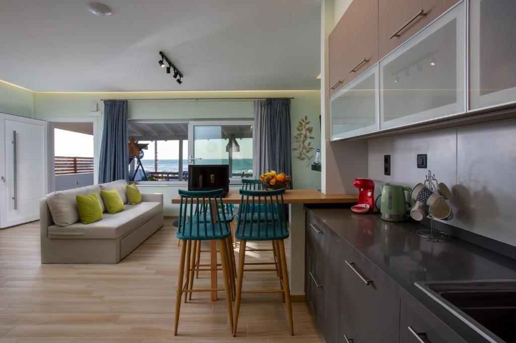 a kitchen and living room with a couch and a table at Kyma Seafront Suite by Estia in Kokkini Khanion