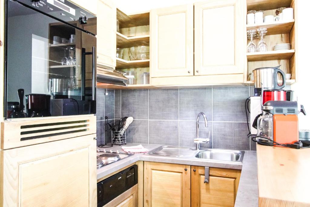 a kitchen with white cabinets and a sink at Spacious Family 2-bed, 2-bath with parking, private piste in Flaine
