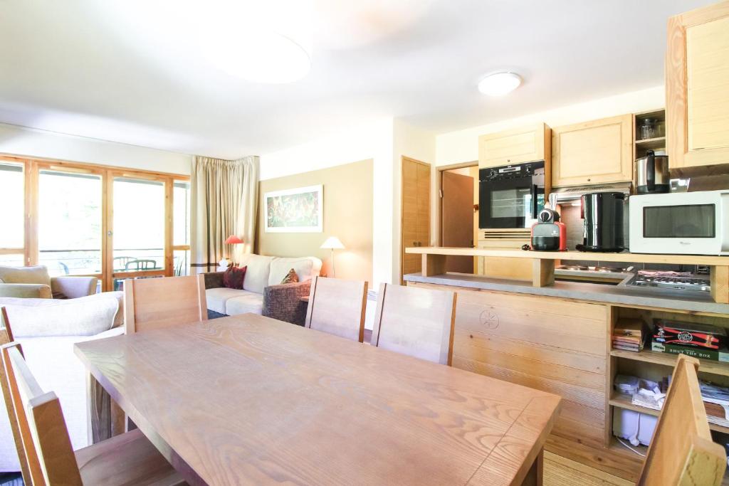 a kitchen and living room with a table and chairs at Spacious Family 2-bed, 2-bath with parking, private piste in Flaine