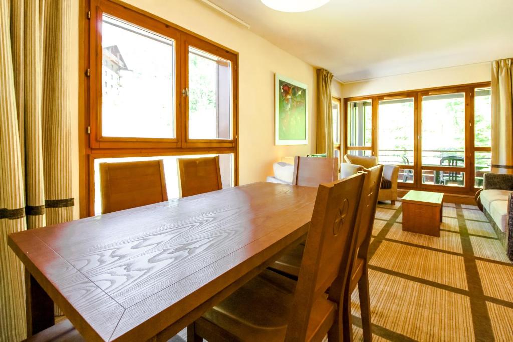 a dining room with a wooden table and chairs at Spacious Family 2-bed, 2-bath with parking, private piste in Flaine