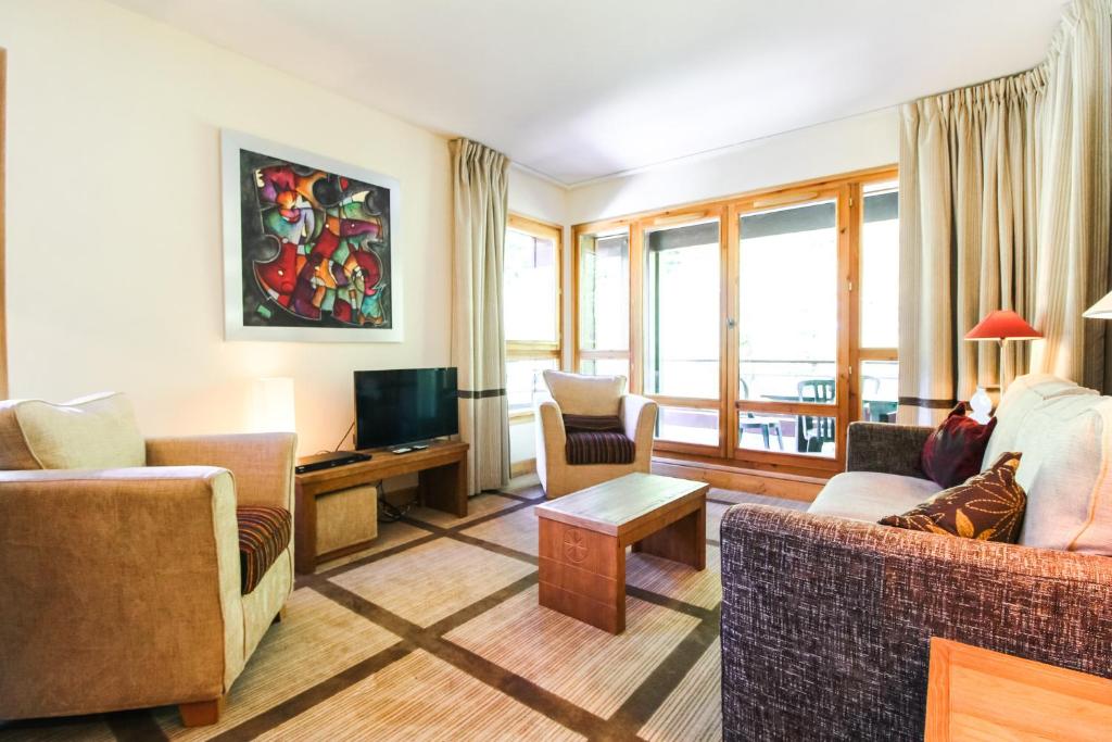 a living room with two couches and a television at Spacious Family 2-bed, 2-bath with parking, private piste in Flaine