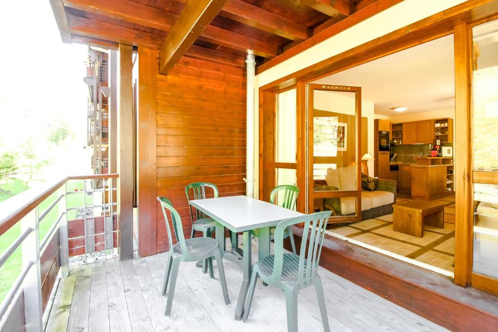 a table and chairs on the balcony of a house at Spacious Family 2-bed, 2-bath with parking, private piste in Flaine