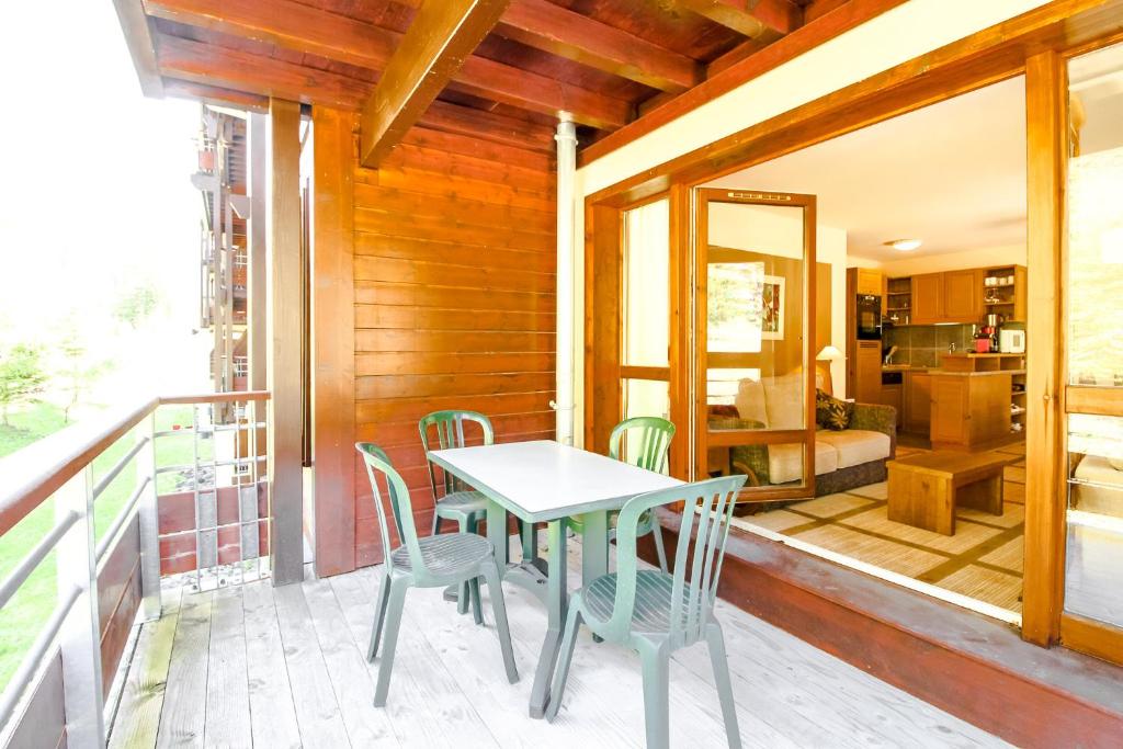 a patio with a table and chairs on a balcony at Spacious Family 2-bed, 2-bath with parking, private piste in Flaine