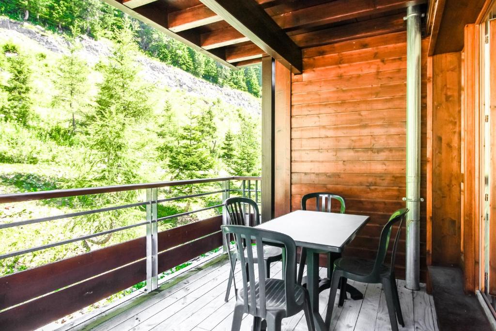 a table and chairs on the balcony of a cabin at Spacious Family 2-bed, 2-bath with parking, private piste in Flaine