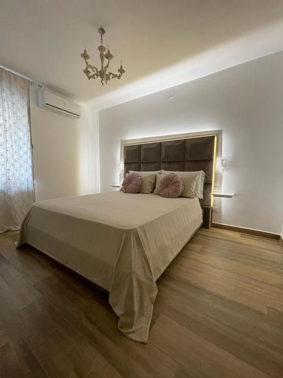 um quarto com uma cama grande e um lustre em B&B Il Gigante em Agrigento