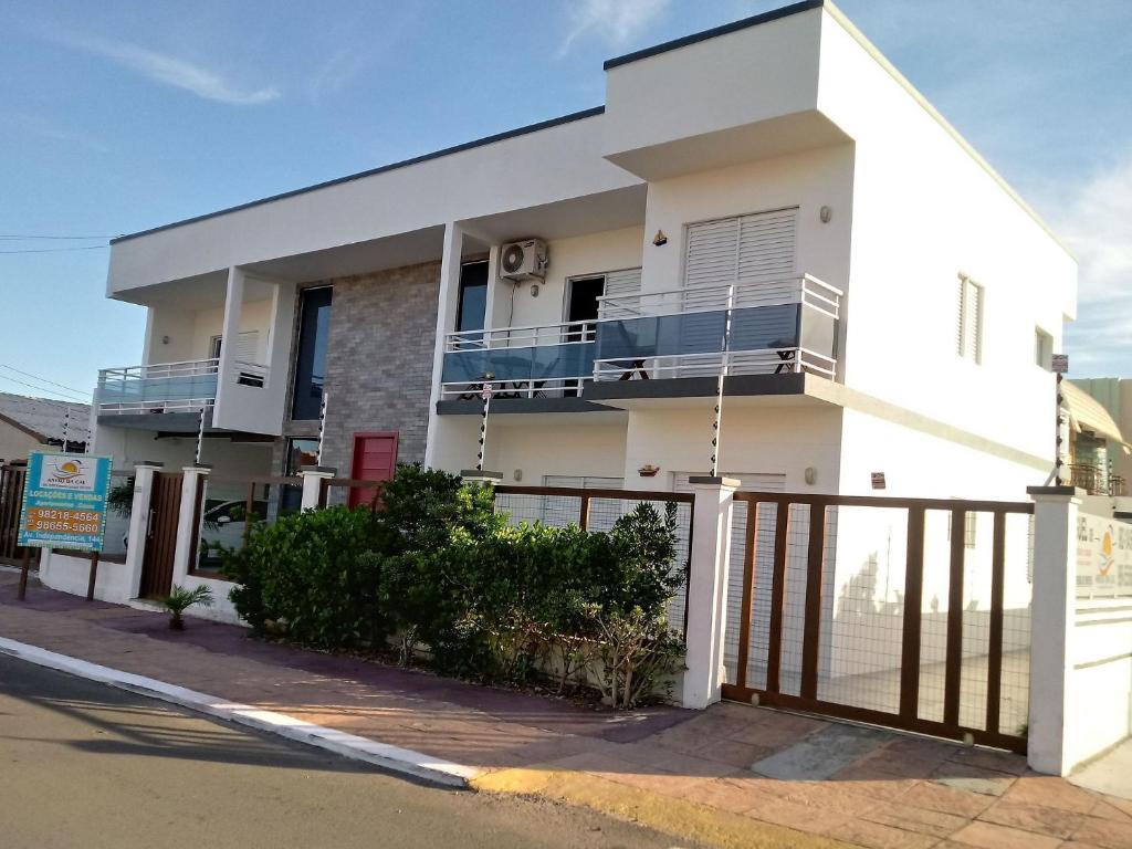 een wit huis met een balkon in een straat bij Anexo da Cal in Torres