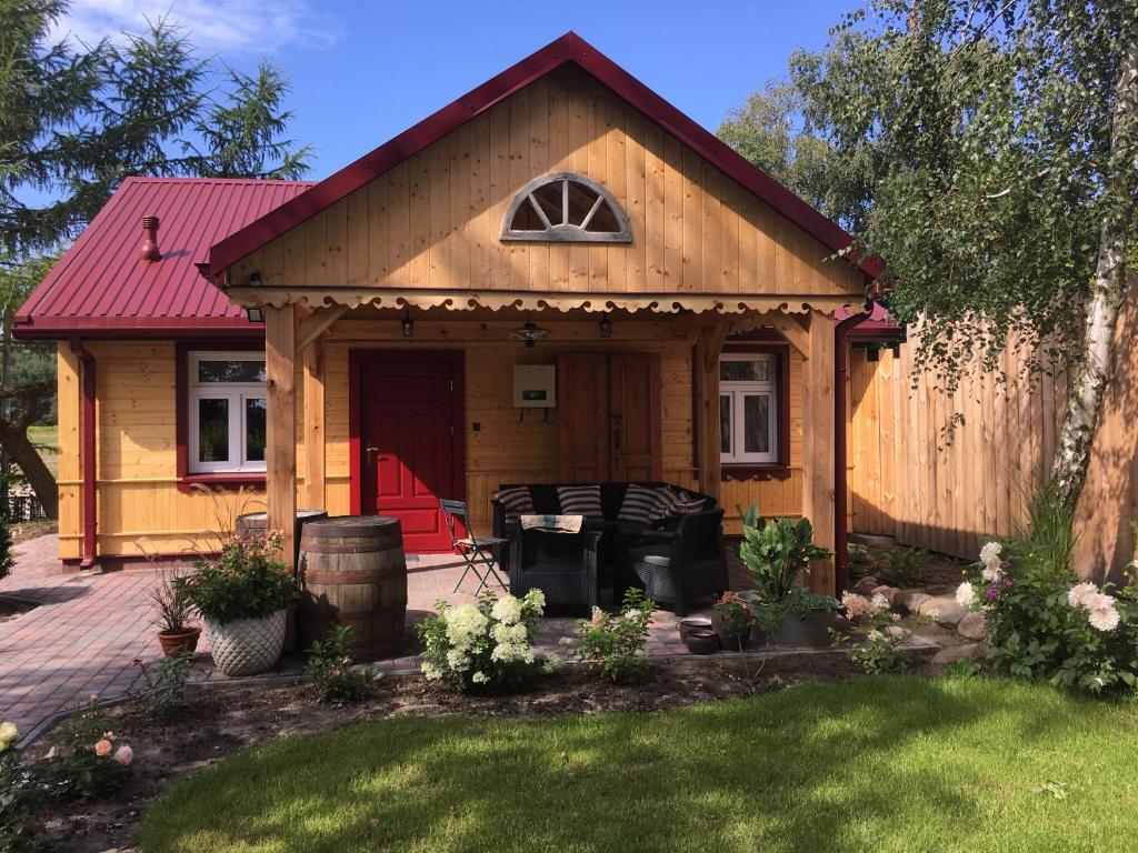 una pequeña casa de madera con techo rojo en Chata 3 Drogi en Janów Podlaski