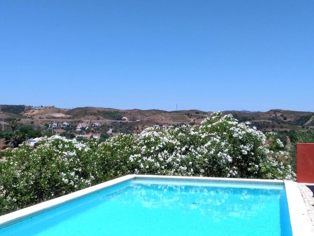 a swimming pool with a view of the mountains at Casa da Achada - Fonte Salgada in Tavira