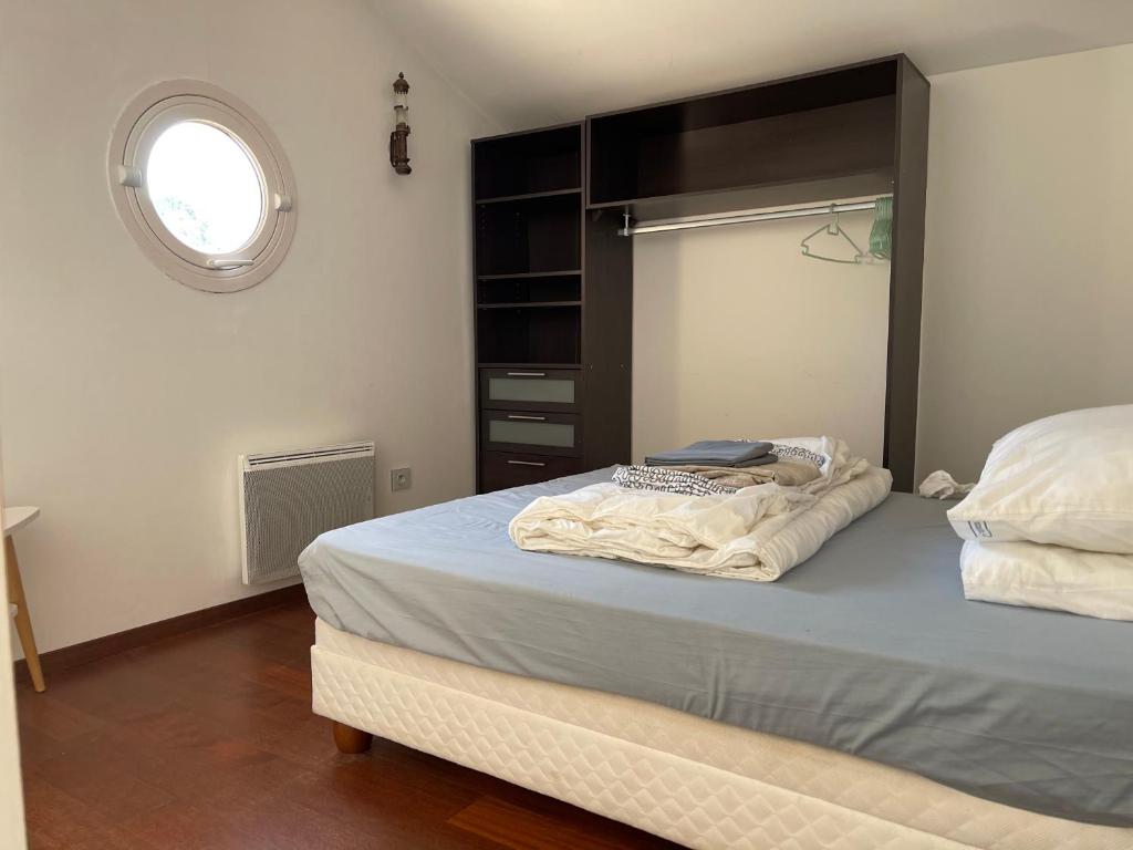 a bedroom with a bed with a black headboard and a window at Latitudes 43 in Porquerolles