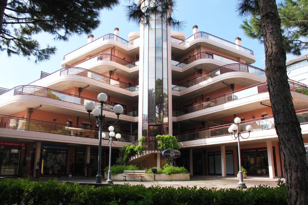 ein großes Gebäude mit Palmen davor in der Unterkunft Residence Crystal Palace in Milano Marittima
