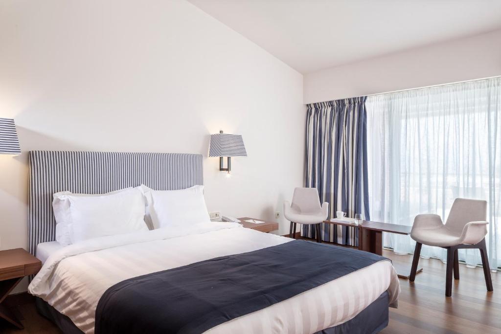 a hotel room with a bed and a desk and a window at Horizon Blu Boutique Hotel in Kalamata