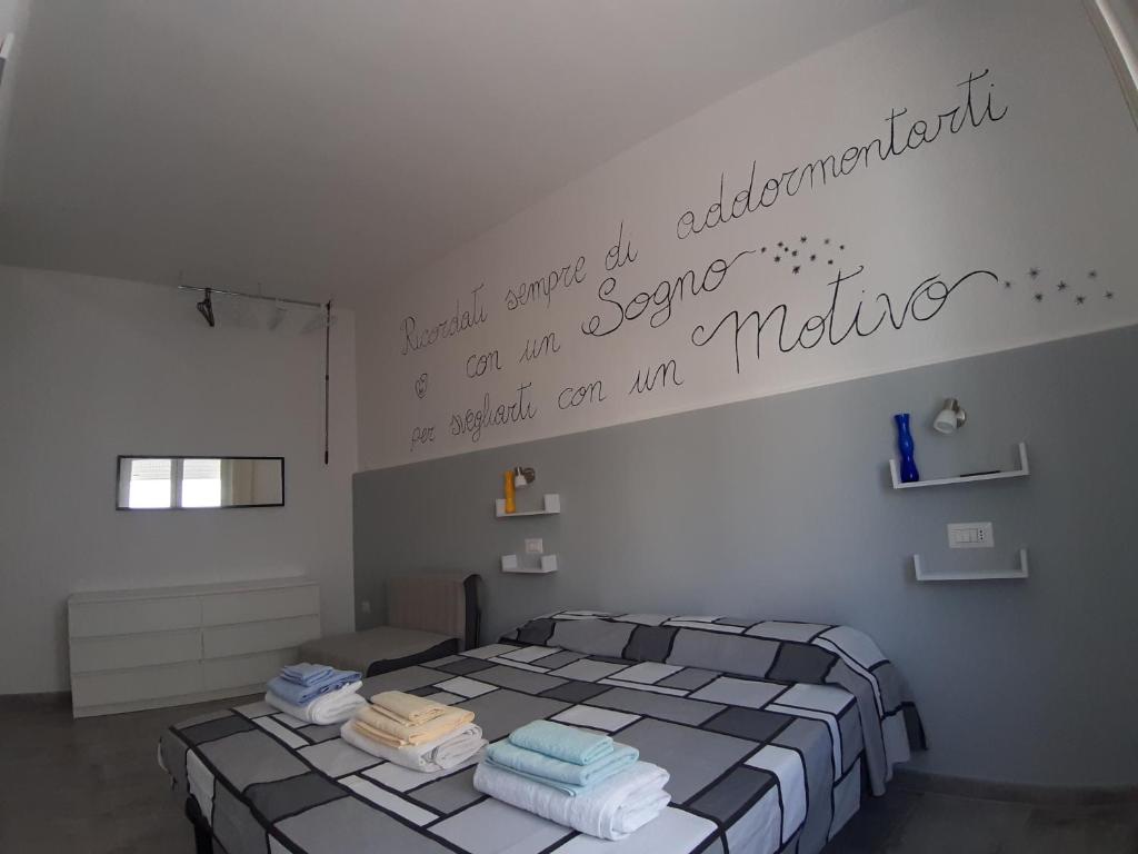 um quarto com uma cama com uma escrita na parede em CASA ALEXSA Early checkin late checkout em Tortolì