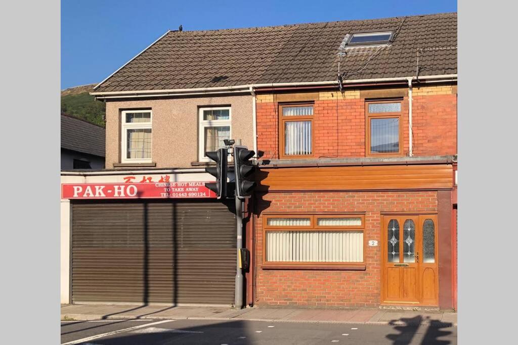 eine Ampel vor einem Gebäude mit einem Parkplatz in der Unterkunft S&Ks in Troed-y-rhiw